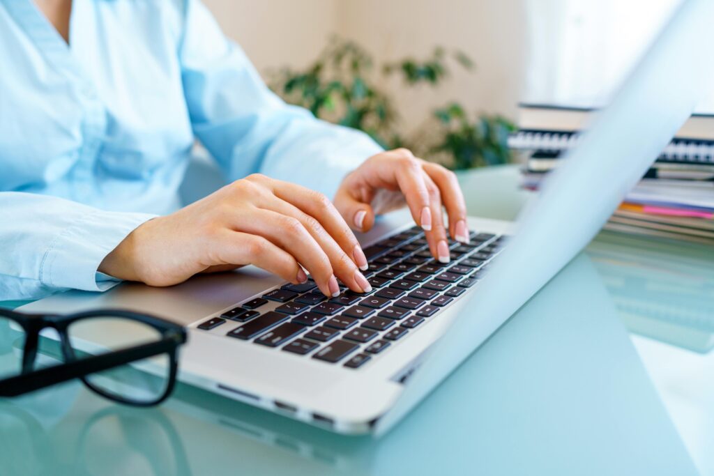 Close-up of female professional typing on laptop