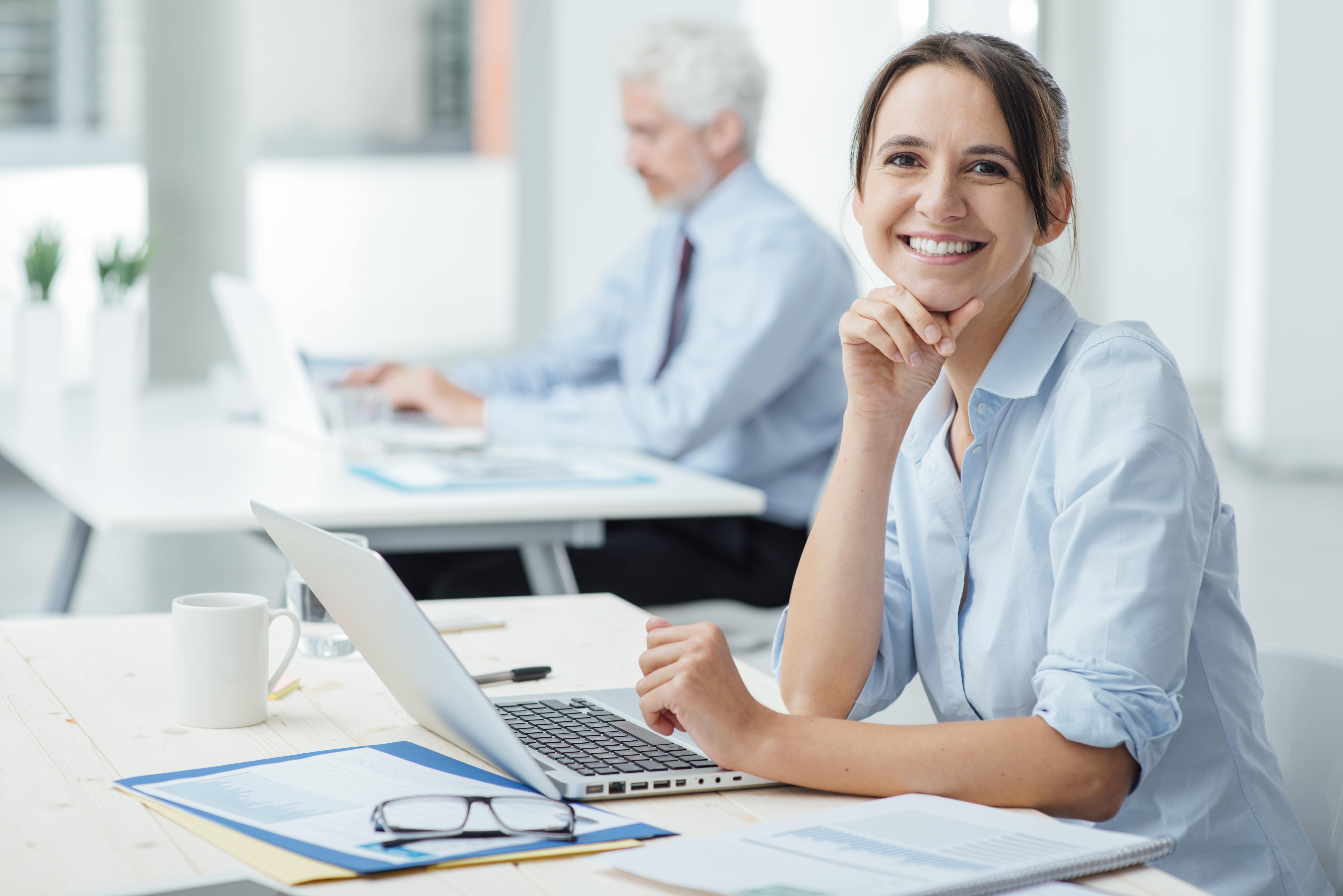 Female employee smiling and using computer